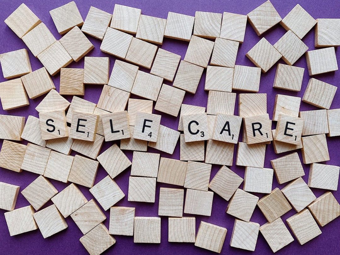 Scrabble tiles spelling out self care